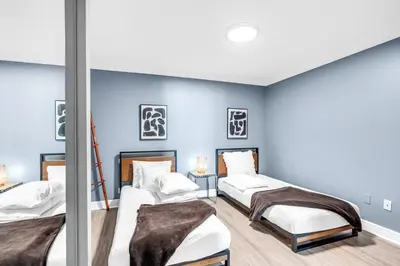 a room with three beds and blue walls at Beachfront Apartment in Miami Beach at the Casablanca Hotel in Miami Beach