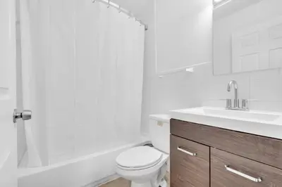 a white bathroom with a toilet and a sink at Beachfront Apartment in Miami Beach at the Casablanca Hotel in Miami Beach