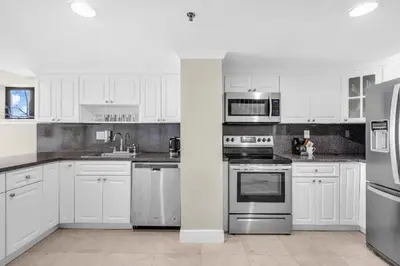 a kitchen with white cabinets and stainless steel appliances at Beachfront Apartment in Miami Beach at the Casablanca Hotel in Miami Beach