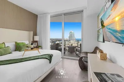 a bedroom with a bed and a view of the city at Insane Ocean View Balcony - Beachfront Resort & Pool in Hollywood