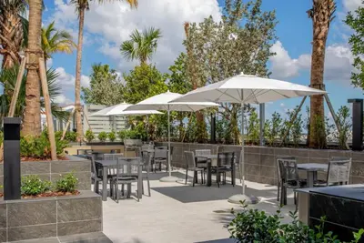 a patio with tables and chairs and umbrellas at Blueground Coral Gables pool wd nr Vizcaya MIA-125 in Miami