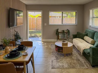 a living room with a couch and a table at 20 Off The Jungle House 10 min Beach & FLL Airport in Fort Lauderdale