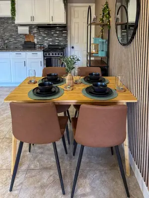 a kitchen with a wooden table with chairs at 20 Off The Jungle House 10 min Beach & FLL Airport in Fort Lauderdale