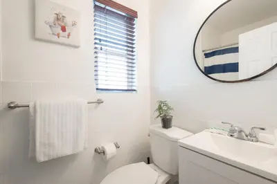 a white bathroom with a toilet and a mirror at B08 10 MIN FROM MIAMI BEACH, Studio, Miami Design District & Wynwood in Miami