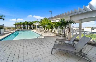 a swimming pool with lounge chairs on a patio at Midtown Miami Marvel- Heated Pool & Prime Location in Miami