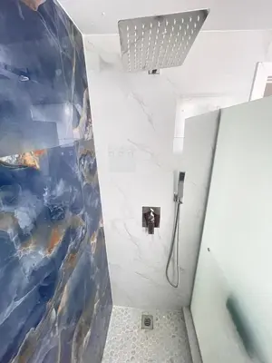 a bathroom with a shower with a painting on the wall at The Azure Terrace Loft in Miami Beach