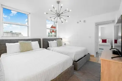 a bedroom with two beds and a tv and a window at Stylish Condo with Panoramic Ocean Views in Miami
