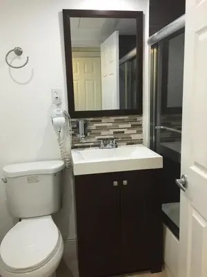 a bathroom with a toilet and a sink and a mirror at Ocean Front Resort Studio in Miami Beach