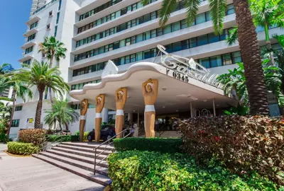 a building with a staircase and palm trees in front of it at Ocean Front Resort Studio in Miami Beach