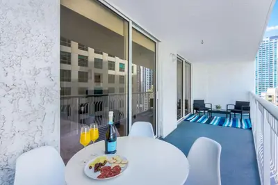 a white table with a plate of food on a balcony at Newly Renovated 1BR Brickell Condo plus Parking in Miami