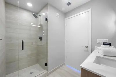 a white bathroom with a shower and a sink at NOK Classy 2BR in Miami Beach in Miami Beach