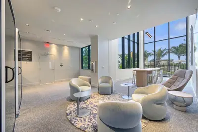 a waiting room with chairs and a table and windows at NOK Classy 2BR in Miami Beach in Miami Beach