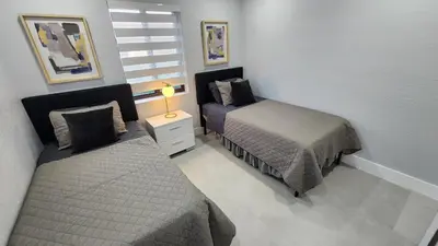 a bedroom with two beds and a night stand with a lamp at NEW house in Miami Casa Calle 19 in Miami