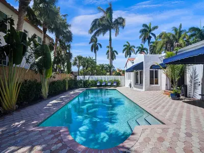 a swimming pool in the backyard of a house with palm trees at Classic 5 Bedroom 4 Bathroom Pool Home in Hollywood