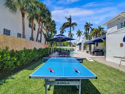 a ping pong table in a yard with palm trees at Classic 5 Bedroom 4 Bathroom Pool Home in Hollywood