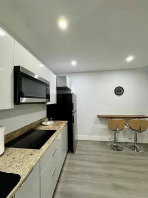 a kitchen with a counter and two stools in it at Elegant Miami South Stay! in Cutler Bay