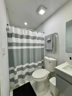 a bathroom with a toilet and a shower curtain at Elegant Miami South Stay! in Cutler Bay