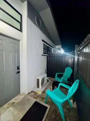 two green chairs sitting on a patio at night at Elegant Miami South Stay! in Cutler Bay