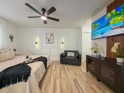 a bedroom with a bed and a flat screen tv at King Comfort Suite Kitchen Wi-Fi Parking in Pembroke Pines