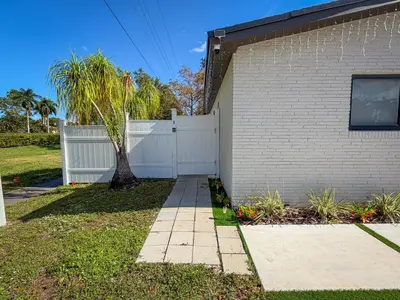 a house with a white fence and a sidewalk at King Comfort Suite Kitchen Wi-Fi Parking in Pembroke Pines