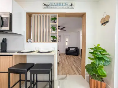 a kitchen and living room with a counter and stools at King Comfort Suite Kitchen Wi-Fi Parking in Pembroke Pines