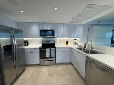 a kitchen with white cabinets and stainless steel appliances at Beachfront two story apartment in Miami Beach