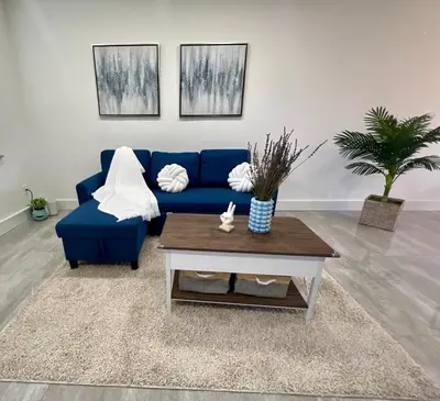 a living room with a blue couch and a coffee table at 20 OFF BLUE WAVE 10min Beach and Airport in Fort Lauderdale