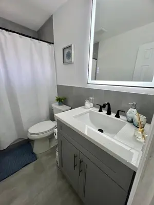 a bathroom with a sink and a toilet and a mirror at 20 OFF BLUE WAVE 10min Beach and Airport in Fort Lauderdale