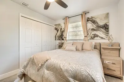 a bedroom with a bed and a ceiling fan at 3 Mi to Port Everglades Modern Getaway with Yard in Dania Beach