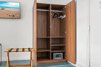a wooden book shelf in a room with a tv at Bluebird Suites at The Apex Miami in Miami Beach
