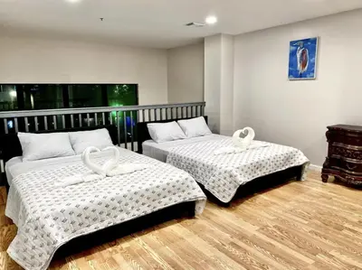 two beds in a room with wooden floors at Miami Beach-Front with Amazing Pool in Miami Beach