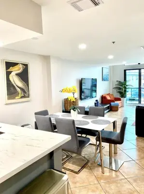 a dining room with a table and chairs and a living room at Miami Beach-Front with Amazing Pool in Miami Beach