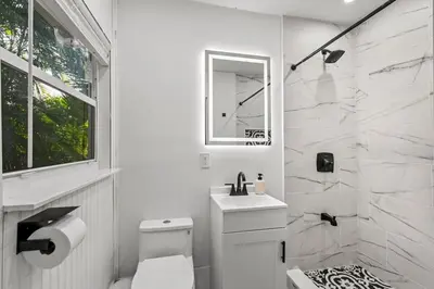 a white bathroom with a toilet and a sink at Newly Renovated Home- Sailboat Bend - Walk to Las Olas - 4 Miles to Beach in Fort Lauderdale