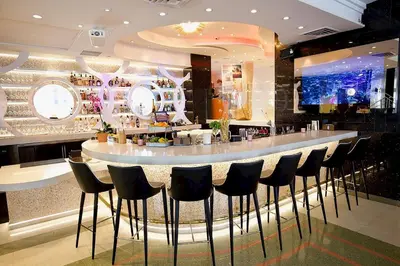 a bar with black stools in a restaurant at Cardozo Hotel in Miami Beach
