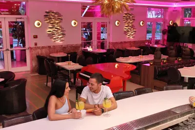 a man and a woman sitting at a table in a restaurant at Cardozo Hotel in Miami Beach