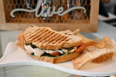 a sandwich and some chips on a white plate at Cardozo Hotel in Miami Beach