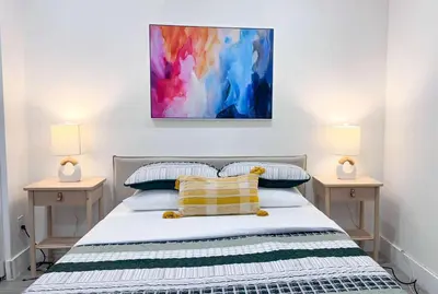 a bedroom with a bed with two nightstands and two lamps at The Hideaway - Wilton Manors in Fort Lauderdale