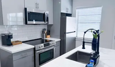 a kitchen with a sink and a stove and a microwave at The Hideaway - Wilton Manors in Fort Lauderdale