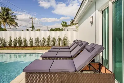 a group of lounge chairs next to a swimming pool at 4 BR home with private pool in Fort Lauderdale