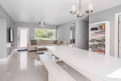 a living room with a white table and a couch at 4 BR home with private pool in Fort Lauderdale
