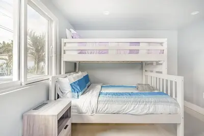 a white bunk bed in a white room with a window at 4 BR home with private pool in Fort Lauderdale