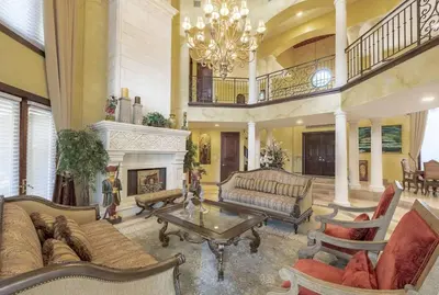 a large living room with a chandelier and a fireplace at Serene 7000 SF Gated Luxury Waterfront Home in Fort Lauderdale