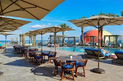 a resort with a pool and tables and umbrellas at Ocean Front Corner 2 Bedroom Low Floor in Hollywood