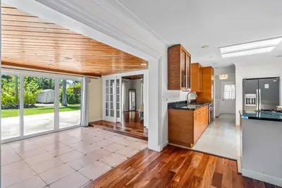 an open kitchen with wooden cabinets and a large window at Brazilian Style Getaway 2 Minutes to Beach in Hollywood