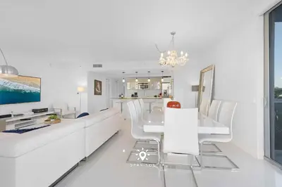 a white living room with a white couch and chairs at Apt with Private Balcony - Incredible Pool in Hallandale Beach