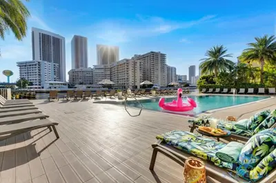 a large swimming pool with a city skyline in the background at Apt with Private Balcony - Incredible Pool in Hallandale Beach