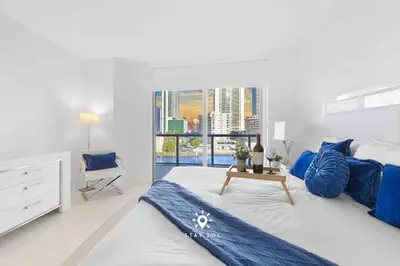 a white bedroom with a large bed and a window at Apt with Private Balcony - Incredible Pool in Hallandale Beach