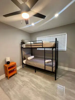 a room with two bunk beds and a ceiling fan at 20 OFF Golden Hour BBQ 10 MIN Beach Airport FL in Fort Lauderdale