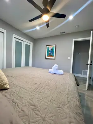 a bedroom with a large bed with a ceiling fan at 20 OFF Golden Hour BBQ 10 MIN Beach Airport FL in Fort Lauderdale