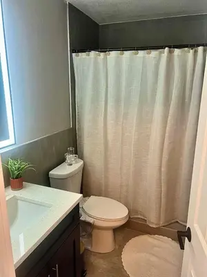 a bathroom with a toilet and a shower curtain at 20 OFF Golden Hour BBQ 10 MIN Beach Airport FL in Fort Lauderdale